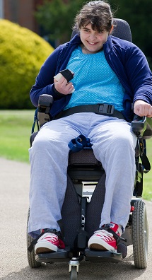 Catherine: young woman smiles while she drives wheelchair