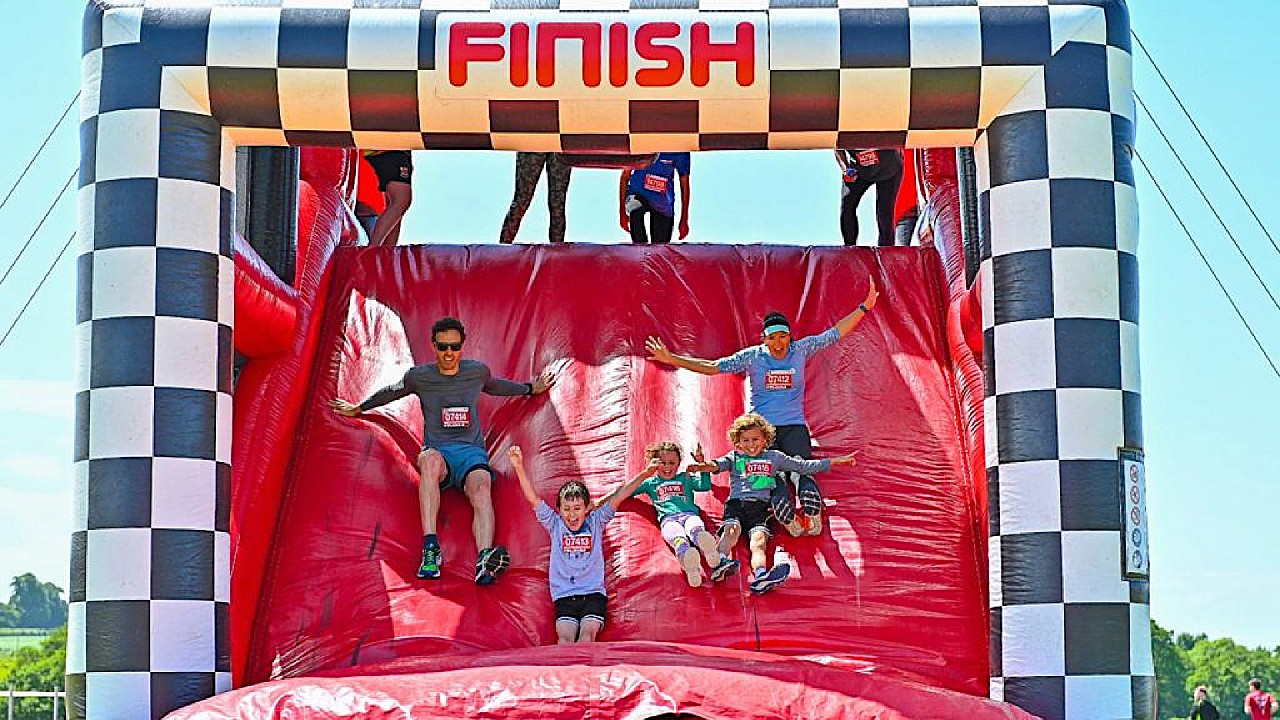Participants sliding down the finish line at 5K inflatables race