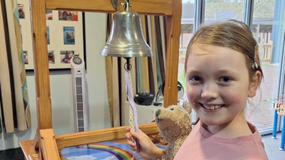 Violet ringing the bell at The Children's Trust