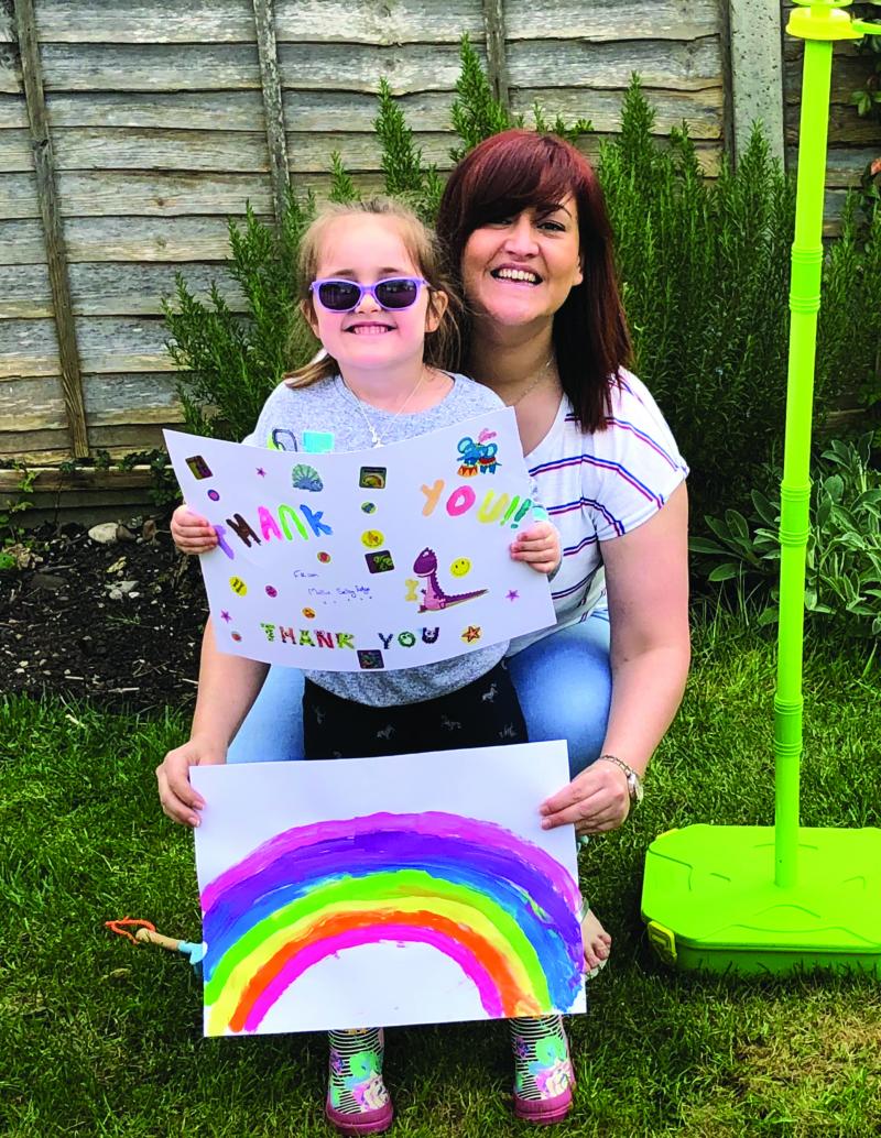 Mollie and her mum holding a picture of a rainbow