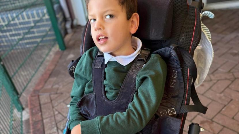 Seb wearing school uniform and looking directly at the camera